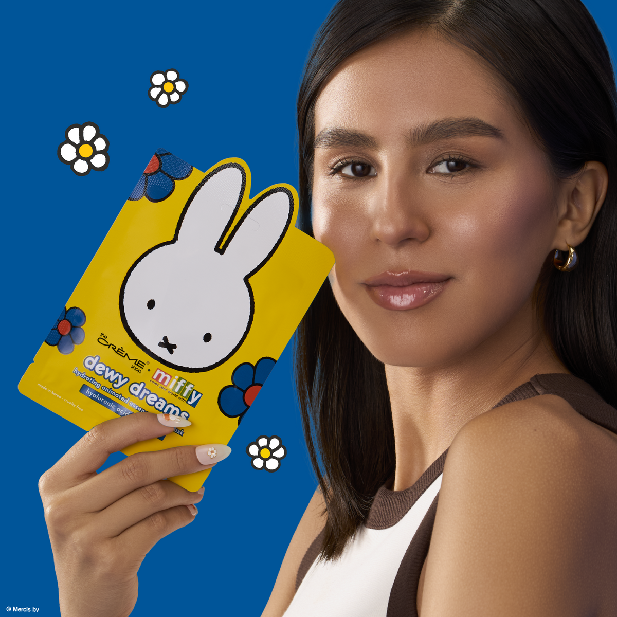Miffy Dewy Dreams Animated Sheet Mask — model holding the yellow mask pouch beside her face
