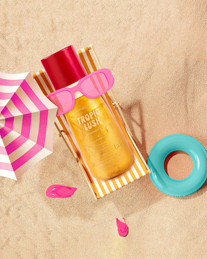 Golden Tropic Lush shimmering oil on a striped beach chair with pink sunglasses